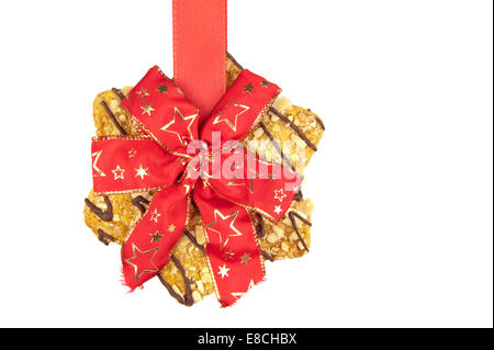 A forma di stella biscotti appesi su rosso annodato Natale nastro celebrativo Foto Stock