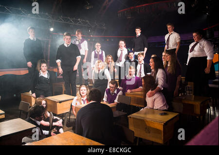 Un gruppo di ragazzi adolescenti e ragazze che agisce effettuando in 'Cusgu'n' Prysur un Welsh langaueg Youth Theatre musical ambientato in un Foto Stock