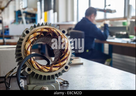 Un lavoratore è la produzione di ricambi elettrici per Zurigo treni tranviaria presso la centrale di manutenzione di garage VBZ Zurigo. Foto Stock