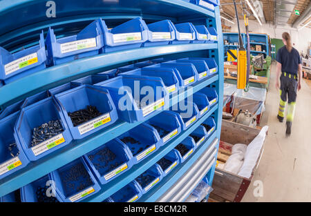 Un rack pieno di scatole per vari dadi e bulloni in una industria meccanica officina Foto Stock