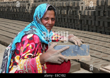 Femmina lavoratore brickyard (20 anni) forma di mattoni di argilla su un campo della Patoki forno di mattoni nei pressi di Lahore, Pakistan Foto Stock