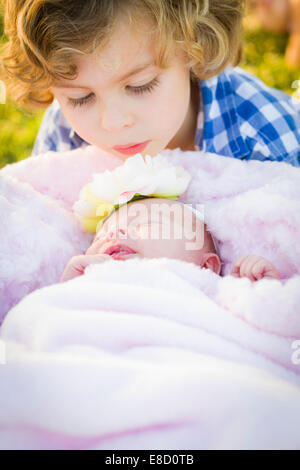 Carino giovane ragazzo guardando il suo neonato ragazza sorella. Foto Stock