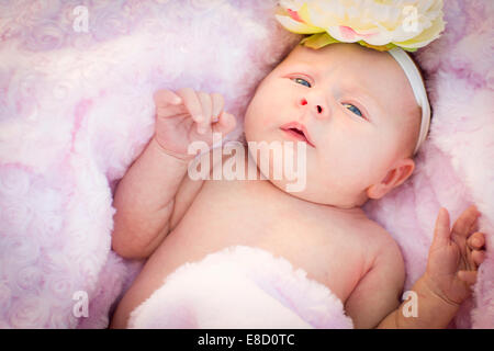 Bella Neonato ragazza posa pacificamente in rosa tenue coperta. Foto Stock