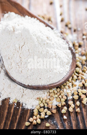 Farina di grano saraceno con alcuni grani scuri su sfondo di legno Foto Stock