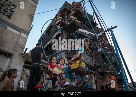 La striscia di Gaza. 5 Ottobre, 2014. Bambini palestinesi giocare su un mini ruota panoramica Ferris in Al-Shejaiya quartiere di Gaza City il secondo giorno di Eid al-Adha, il 5 ottobre, 2014. © Wissam Nassar/Xinhua/Alamy Live News Foto Stock