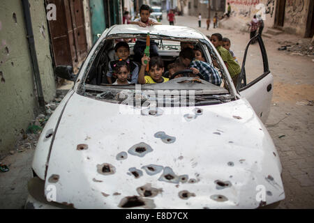 La striscia di Gaza. 5 Ottobre, 2014. Bambini palestinesi gioco all'interno di una vettura distrutta in Al-Shejaiya quartiere di Gaza City il secondo giorno di Eid al-Adha, il 5 ottobre, 2014. © Wissam Nassar/Xinhua/Alamy Live News Foto Stock