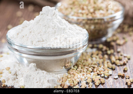 Farina di grano saraceno con alcuni grani scuri su sfondo di legno Foto Stock