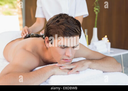 L'uomo riceve stone massaggio presso il centro termale Foto Stock