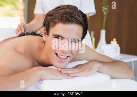 Uomo bello ricevere stone massaggio presso il centro termale Foto Stock