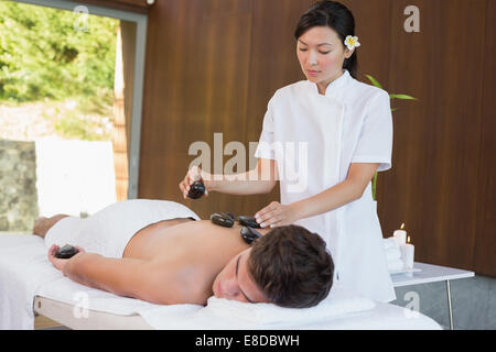 L'uomo riceve stone massaggio presso il centro termale Foto Stock
