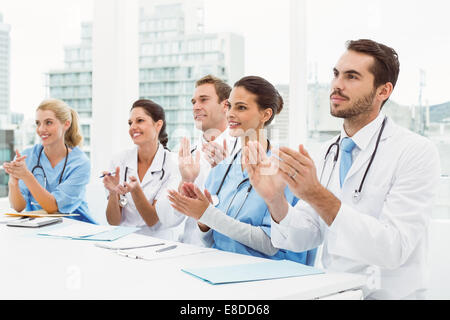 I medici battendo le mani in riunione Foto Stock