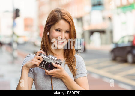 Allegro fotografo in piedi fuori sorridente in telecamera Foto Stock