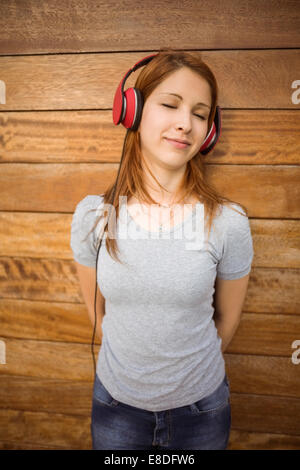 Donna in piedi e ascoltare la musica con gli occhi chiusi Foto Stock