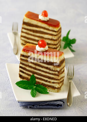 Strati di pan di spagna con ciliegie. Ricetta disponibile. Foto Stock