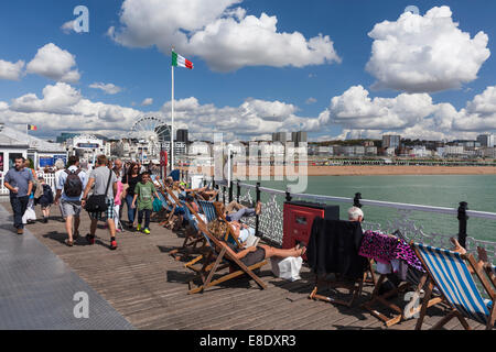 Persone rilassante sul molo di Brighton su una giornata d'estate. Brighton, East Sussex, England, Regno Unito Foto Stock