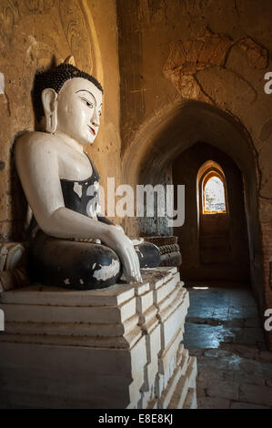 Architettura antica di vecchi templi buddisti a Bagan unito, Myanmar (Birmania). Golden statua del Buddha uno all'interno della pagoda rovine Foto Stock