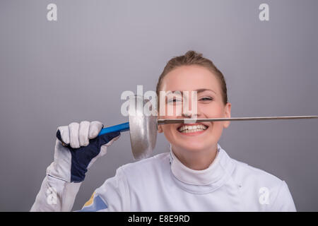 Giovane donna impegnandosi nella scherma Foto Stock