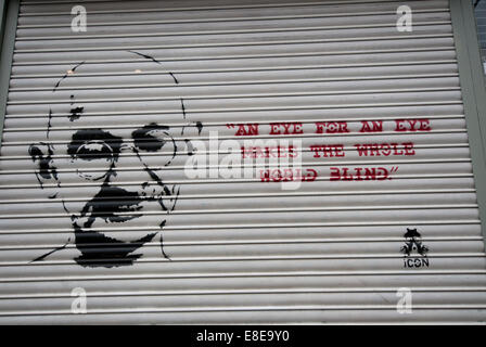 Citazione da Gandhi "occhio per occhio rende cieco il mondo intero' graffitied sulla parete Foto Stock