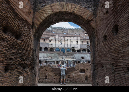 Uomo che guarda in il Colosseo o il Colosseo aka Anfiteatro Flavio (Anfiteatro Flavio, Colosseo), Roma, Italia Foto Stock