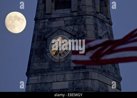 Gosen, New York, Stati Uniti d'America. 6 Ottobre, 2014. Il quasi-luna piena splende accanto al campanile della prima Chiesa Presbiteriana in Gosen, New York, come una bandiera americana soffia nella brezza della sera. La ceratura gibbous moon era 98 percento illuminata e sarà piena il 7 ottobre. © Tom Bushey/ZUMA filo/Alamy Live News Foto Stock