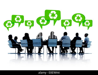 Sagome di uomini di affari in una conferenza con il discorso di bolle al di sopra di esse con i simboli di riciclaggio in loro. Foto Stock