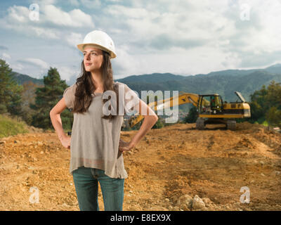 Giovani caucasici architetto femmina sul sito di costruzione cercando felice Foto Stock