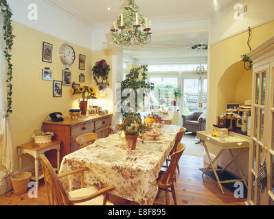 Rose panno modellato sulla tabella impostata per il compleanno di tè in pallido giallo townhouse sala da pranzo Foto Stock