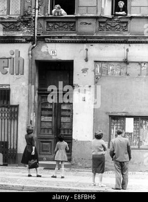 L'edificio è in East-Berlin, la strada di fronte a Berlino Ovest - Persone da est- e Berlino Ovest parlare l uno con l altro da guardare fuori delle loro finestre in primo piano o cercando fino dalla strada. Le porte e le finestre al piano terra sono sigillati o chiudere murata. Dal 13 agosto 1961, il giorno di inizio della costruzione del muro di Berlino, fino al 9 novembre 1989, il giorno in cui il muro è caduto, la Repubblica federale di Germania e della Repubblica democratica tedesca sono stati separati dalla cortina di ferro. Foto Stock