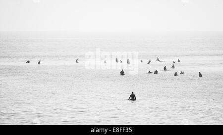 Grande gruppo di surfisti in ocean è in attesa di prendere un'onda Foto Stock