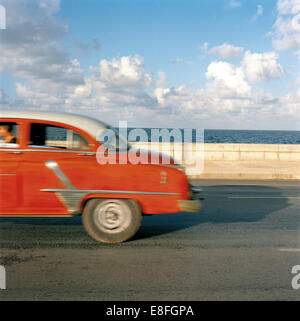 Vintage auto guidando lungo il Malecon, Havana, Cuba Foto Stock