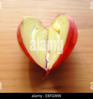 A forma di cuore ad uno spicchio di aglio tagliato a metà Foto Stock