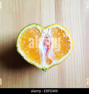 A forma di cuore ad arancio tagliate a metà Foto Stock
