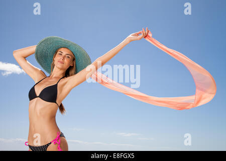 Donna in bikini che tiene sopra la testa una sciarpa di seta, Città del Capo, Capo Occidentale, Sudafrica Foto Stock