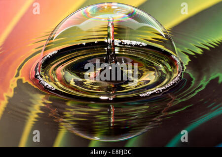 Gocce d'acqua sulla bolla con sfondo arcobaleno Foto Stock