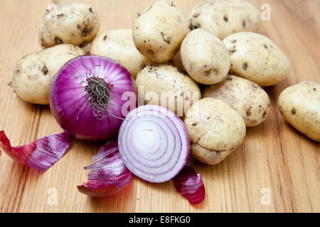 Primo piano di cipolle rosse e patate fresche su un tavolo Foto Stock