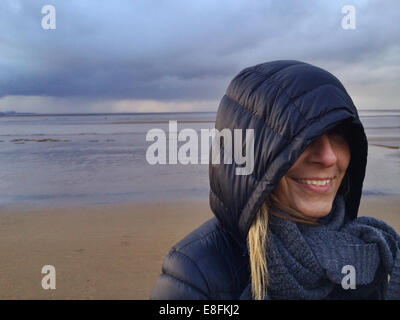 Somerset, Regno Unito Donna sorridente in spiaggia durante le tempeste