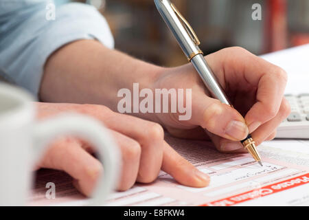 Close up della donna la firma di un documento Foto Stock