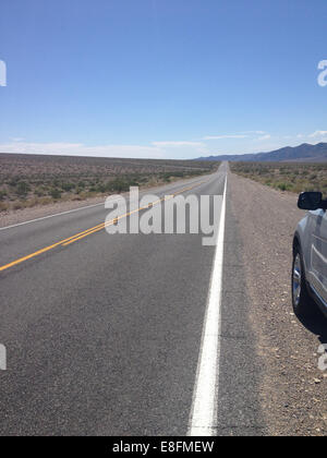 Auto parcheggiata su una strada desertica, Nevada, USA Foto Stock