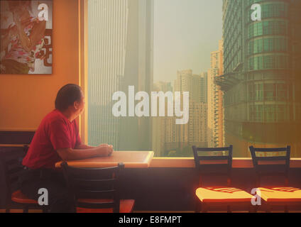 Cina, Shanghai, uomo seduto a tavola Foto Stock