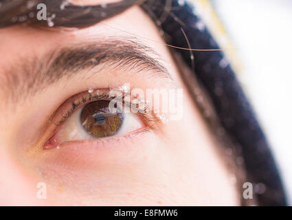 I fiocchi di neve su un Uomo's eye Foto Stock