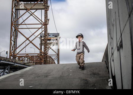 Ragazzo che corre giù da levee nel nono rione inferiore, New Orleans, Louisiana, Stati Uniti Foto Stock