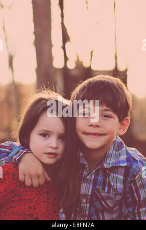 Ritratto di sorella e fratello che si abbracciano nel parco, USA Foto Stock