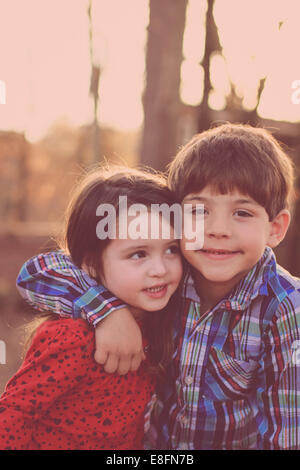 Ritratto di sorella e fratello che si abbracciano nel parco, USA Foto Stock