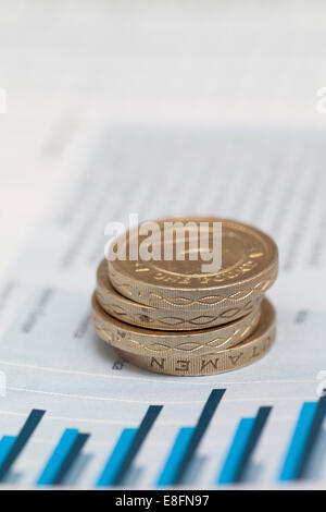 Pila di monete sterlina sui dati finanziari Foto Stock