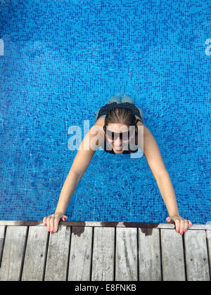 La donna lo stiramento in piscina Foto Stock