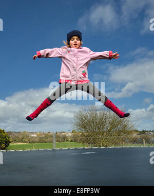 Ragazza in età prescolare (2-3) di saltare sul trampolino Foto Stock