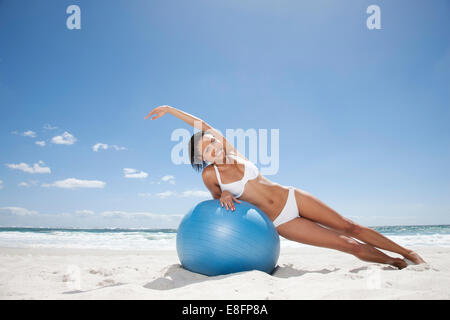 Ritratto di giovane donna che si esercita sulla spiaggia con palla fitness Città del Capo, Capo Occidentale, Sud Africa Foto Stock