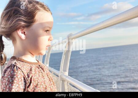 Ragazza in piedi sulla barca che guarda al mare Foto Stock