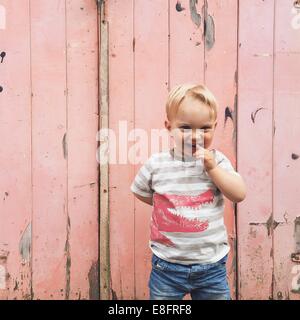 Ragazzo sorridente in piedi fuori porta di garage Foto Stock