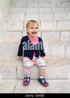Ritratto di ragazza (18-23 mesi) seduti sui gradini Foto Stock